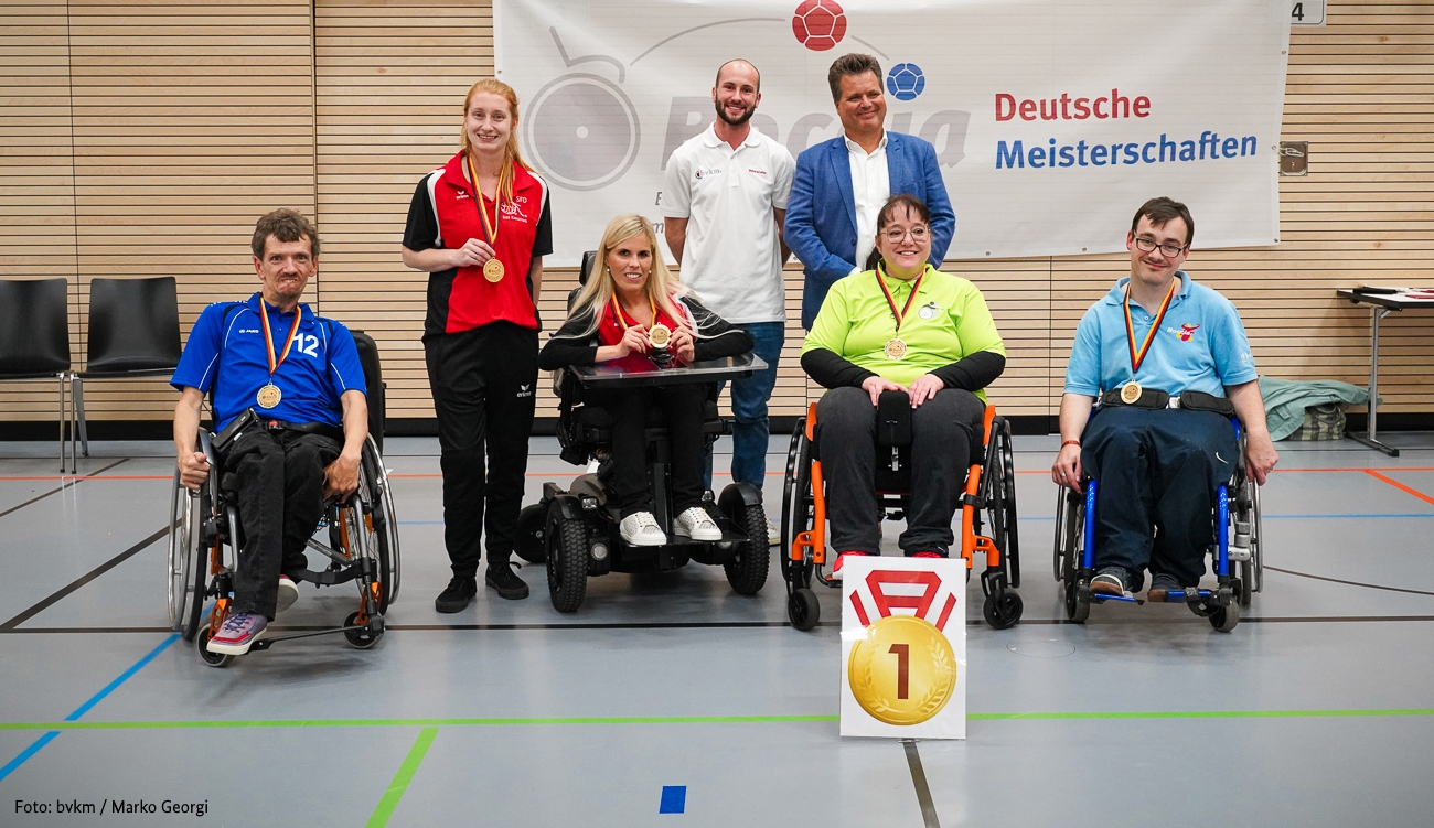 Gruppenfoto Jürgen Dusel mit den Athlet*innen. Zu sehen sind sieben Personen.